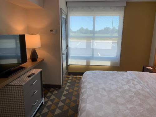 a bedroom with a bed and a television and a window at Holiday Inn Martinsburg by IHG in Martinsburg