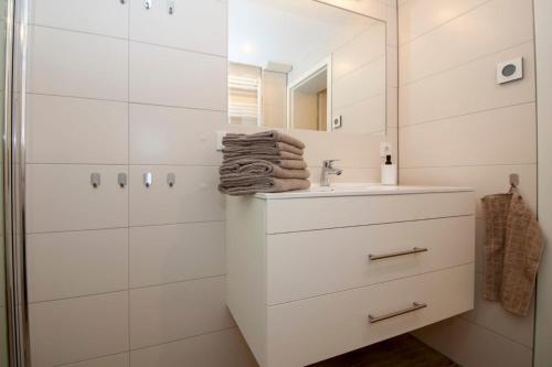 ein weißes Badezimmer mit einem Waschbecken und einem Spiegel in der Unterkunft Ferienwohnung am Schloss in Wernigerode