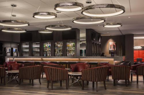 a restaurant with chairs and a bar with lights at Holiday Inn Winnipeg-South by IHG in Winnipeg
