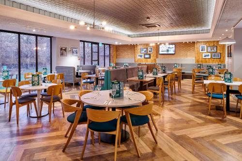 a dining room with tables and chairs and windows at Holiday Inn Taunton M5, Jct25 by IHG in Taunton