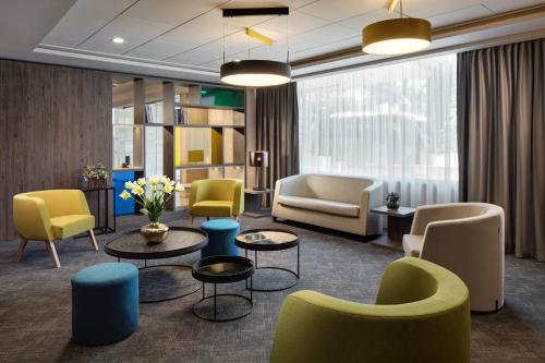 a living room with chairs and tables and chairs at Holiday Inn Rome - Eur Parco Dei Medici by IHG in Rome