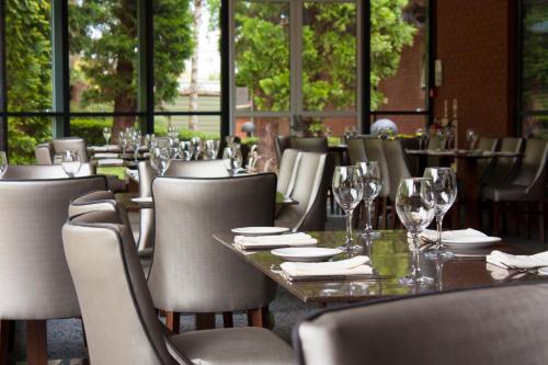 a restaurant with tables and chairs with wine glasses at Holiday Inn Telford Ironbridge by IHG in Telford