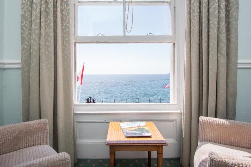 a window with a view of the ocean in a room at The Queens Hotel in Penzance