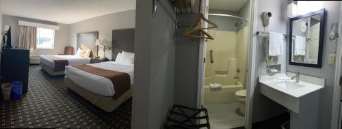 AdamsにあるAdams Inn and Suitesのベッドとバスルーム付きのホテルルームです。