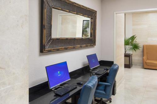 an office with two computers on a desk with a mirror at Holiday Inn Hotel Port of Miami-Downtown by IHG in Miami