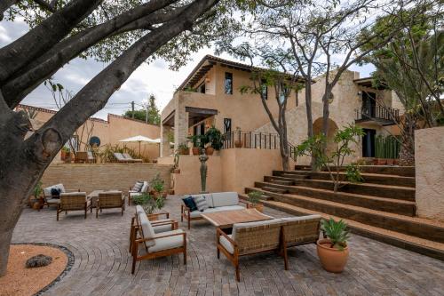 a patio with chairs and tables and a house at Hotel Casa Santo Origen in Oaxaca City