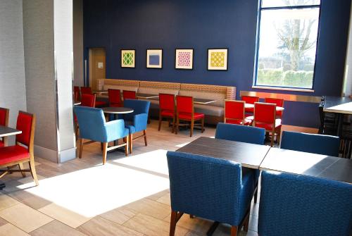 ein Speisesaal mit Tischen und Stühlen in einem Restaurant in der Unterkunft Holiday Inn Express Vancouver Airport-Richmond by IHG in Richmond