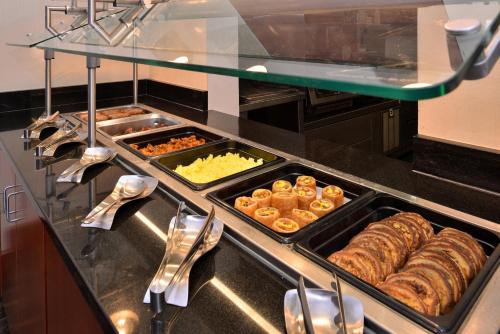 ein Buffet mit Tabletts mit Gebäck und anderen Speisen in der Unterkunft Holiday Inn Madison at The American Center by IHG in Madison