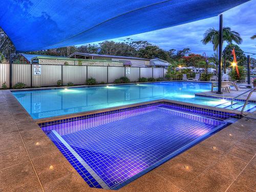 una gran piscina con luces moradas. en Anchorage Holiday Park, en Iluka