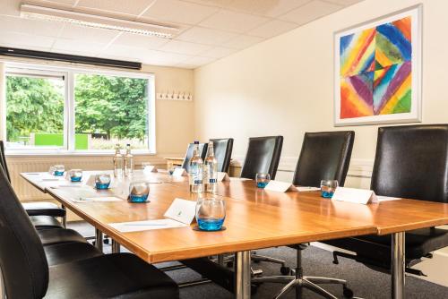 a conference room with a long wooden table and chairs at Holiday Inn Lancaster by IHG in Lancaster