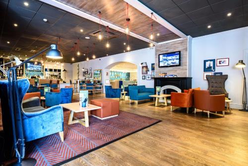 un ristorante con sedie blu e tavoli in una stanza di Holiday Inn Portsmouth by IHG a Portsmouth