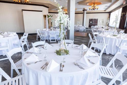 a table set up for a wedding with white tables and chairs at Holiday Inn St. Louis Airport West Earth City by IHG in Earth City