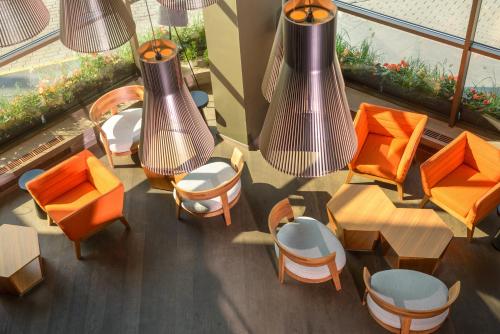 an overhead view of a restaurant with orange chairs and tables at Holiday Inn Vilnius by IHG in Vilnius
