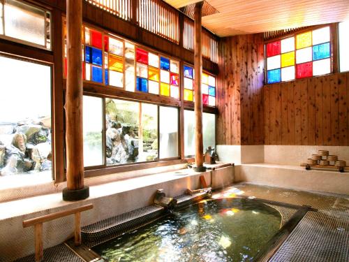 Sumiyosiya Ryokan في نوزاوا أونسن: حمام مع حوض استحمام ونوافذ زجاجية ملطخة