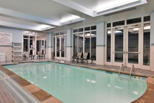 a large swimming pool with blue water in a building at Holiday Inn Kansas City Airport, an IHG Hotel in Kansas City