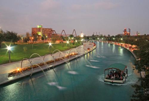 a boat in a river with a roller coaster at Holiday Inn Monterrey-Parque Fundidora by IHG in Monterrey