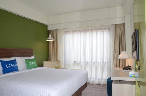a bedroom with a large white bed and a window at Ion Bali Benoa in Nusa Dua