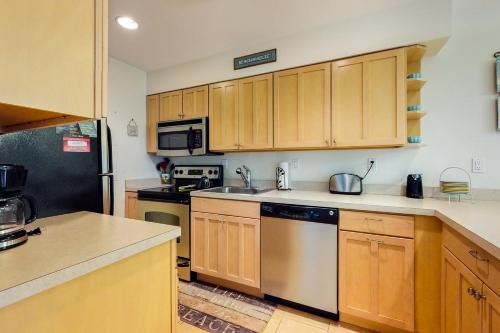 a kitchen with wooden cabinets and stainless steel appliances at Sea Colony - 1804 Doubles in Bethany Beach