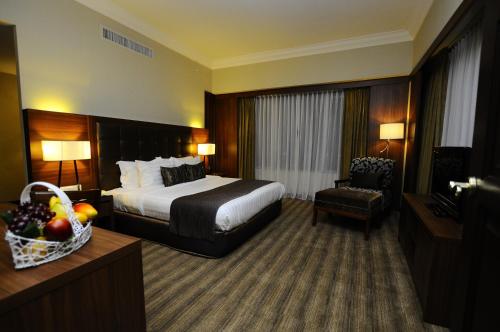 een hotelkamer met een bed en een stoel bij The Katerina Hotel in Batu Pahat