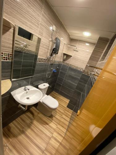 a bathroom with a white toilet and a sink at EagleNest at Marina Cove Resort in Lumut
