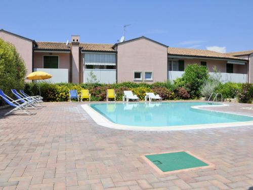 a swimming pool with chairs and an umbrella at Holiday Home in Lazise near Lake Garda in Lazise