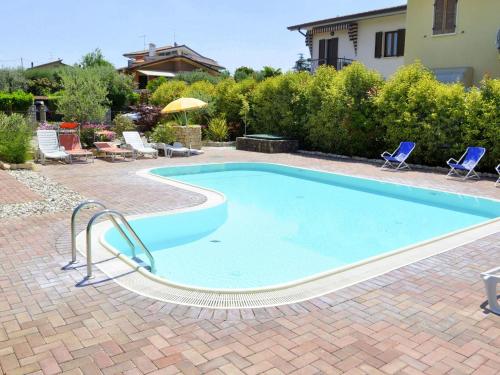 a swimming pool in a yard with chairs and a house at Holiday Home in Lazise near Lake Garda in Lazise