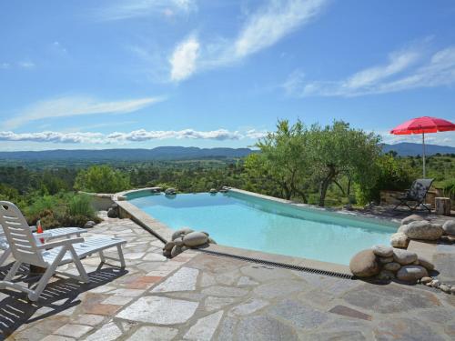 einen Pool mit einem Stuhl und einem Sonnenschirm in der Unterkunft Heritage Villa in Les Mages with Swimming Pool in Les Mages