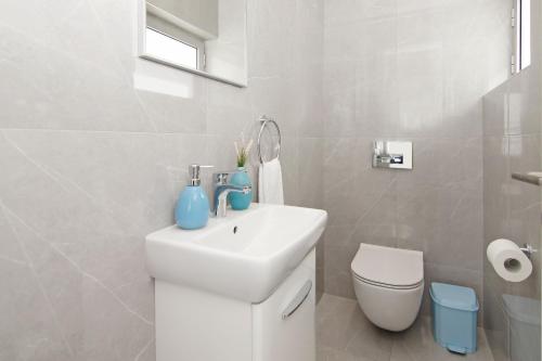 a white bathroom with a sink and a toilet at Villa Medusa in Protaras