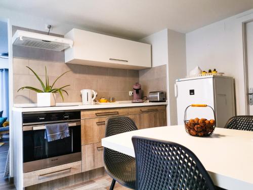 une cuisine avec une table, des chaises et un réfrigérateur dans l'établissement Carpe Diem - cote-montagnes, à Oderen