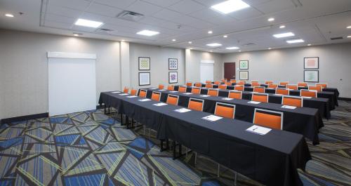 a room with rows of tables and orange chairs at Holiday Inn Express & Suites Tupelo by IHG in Tupelo