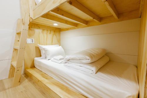 a bunk bed with white sheets and pillows in a room at Step Inn Myeongdong 1 in Seoul