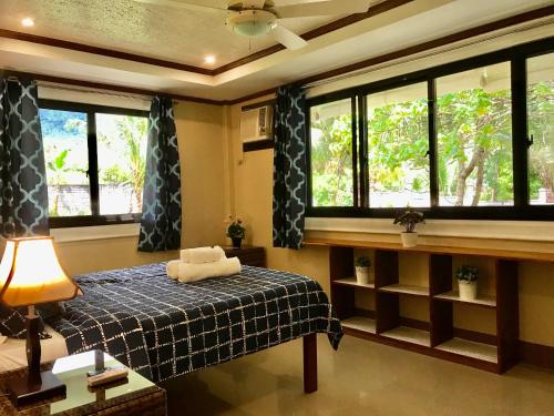 - une chambre avec un lit, des fenêtres et un plafond dans l'établissement Kinghorn Garden House Resort, à Mambajao