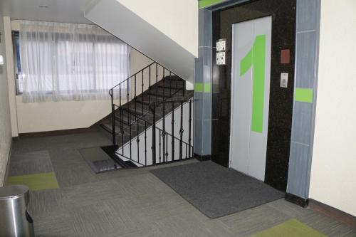a staircase in a building with a green sign on the wall at Hotel Corona Real in Mexico City