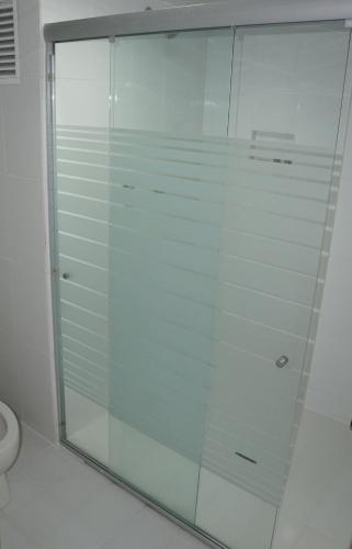 a glass shower in a bathroom with a toilet at Hotel Corona Real in Mexico City