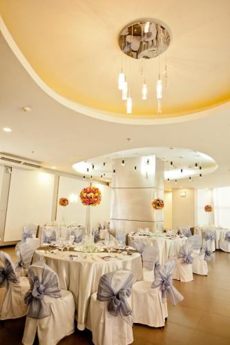a banquet hall with white tables and chairs with bows at The Exchange Regency Residence Hotel Managed by HII in Manila