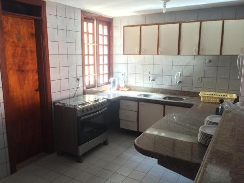 A kitchen or kitchenette at Linda casa Porto das Dunas: 4 suítes, churrasqueira e piscina