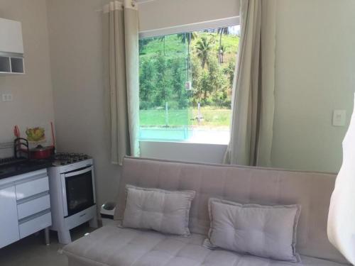 uma sala de estar com um sofá e uma grande janela em Gravatá beach flats em São José da Coroa Grande