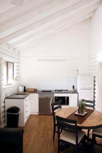 a kitchen with a wooden table and a table and chairs at Palmers Lane Estate Hunter Valley in Pokolbin