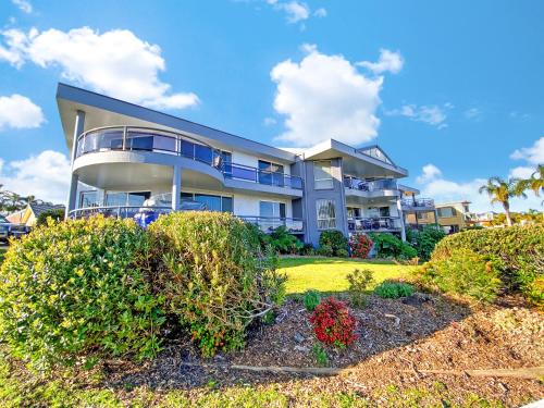 a large house with bushes in front of it at Top Of The Quays in Merimbula