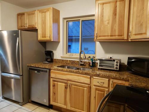 a kitchen with wooden cabinets and a stainless steel refrigerator at HEART OF Denver*Sleeps 10 in Denver
