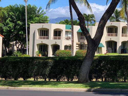 a white building with a tree in front of it at Palms at Wailea Condo 1802 in Wailea