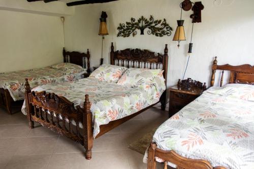 a bedroom with two beds and two lamps at Villa Patty in Tibasosa