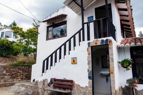 a white house with a staircase and a door at Villa Patty in Tibasosa