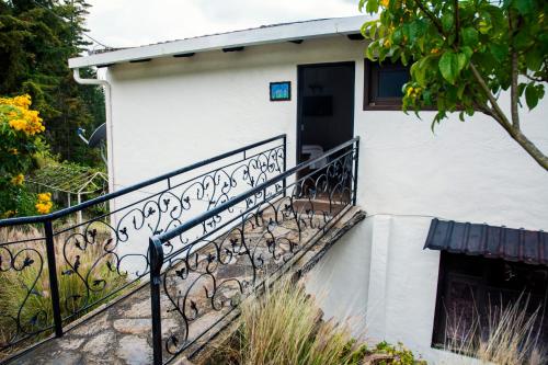 a white building with a black railing and a door at Villa Patty in Tibasosa