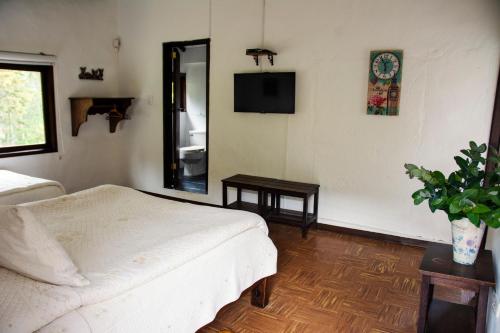 a bedroom with a bed and a mirror and a tv at Villa Patty in Tibasosa