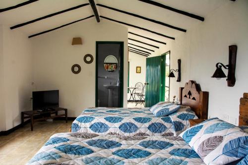 a bedroom with two beds and a tv at Villa Patty in Tibasosa