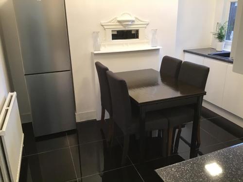 a small kitchen with a table and a refrigerator at Residential Quarters, General Gordon Square in London