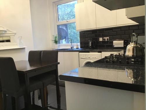 a kitchen with a stove and a counter top at Residential Quarters, General Gordon Square in London