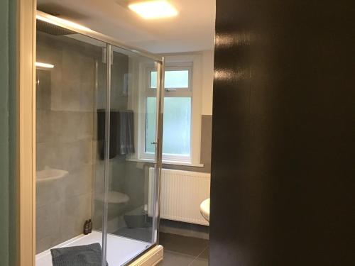 une salle de bain avec une douche en verre et des toilettes dans l'établissement Residential Quarters, General Gordon Square, à Londres