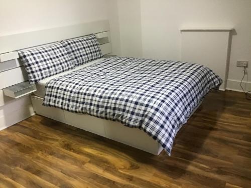 un lit avec une couverture à carreaux noirs et blancs dans l'établissement Residential Quarters, General Gordon Square, à Londres